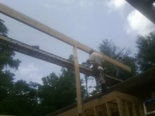 Carpenter setting a ridge beam over a new addition frame — Ice Dam Removal by Roofing Brothers in Little Ferry