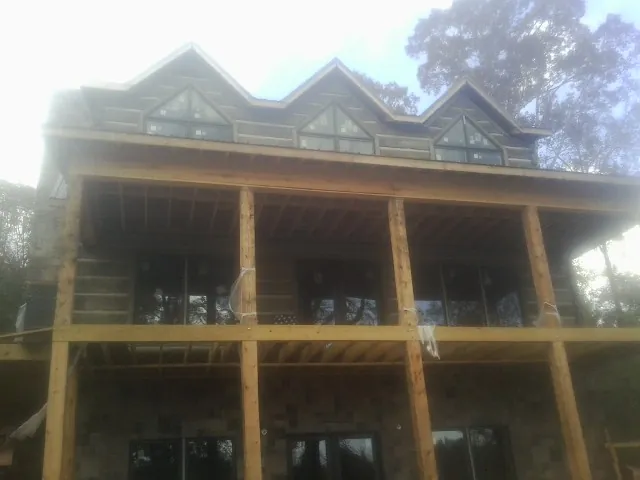 Dormers and porch framing on a large log home under construction — Roof Coating work by our crew in Little Ferry