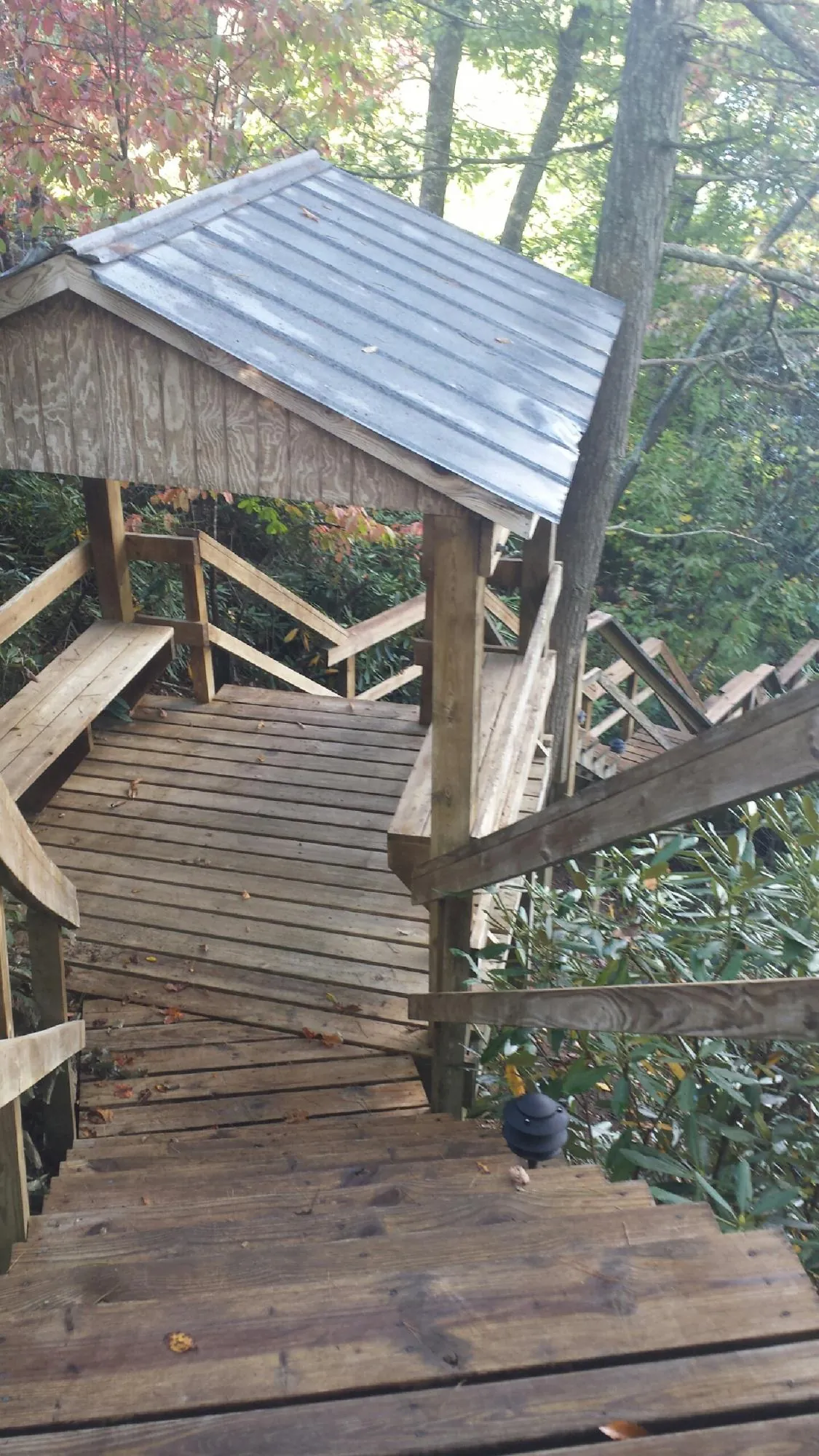 Metal roofed shelter over wooden steps on a wooded walkway — Skylight Repair & Installation work by our crew in Little Ferry